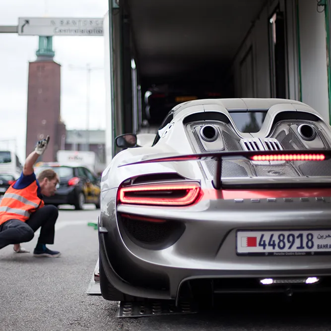 A Porsche 918 being loaded into the covered trailer